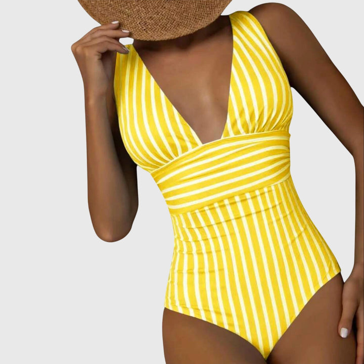 Bañador de mujer que estiliza la figura, con rayas y un atractivo escote V. Ideal para lucir en la playa.