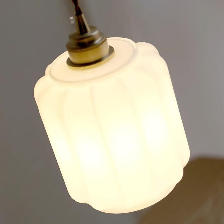 Lámpara de diseño exclusivo con pantalla de cristal blanco y estructura metálica elegante.