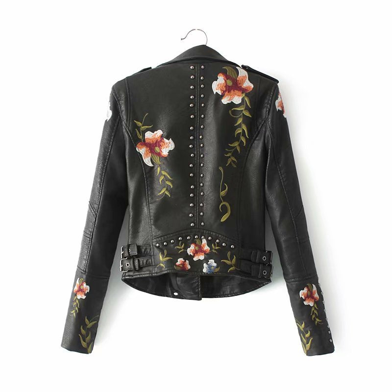 Chaqueta negra de cuero sintético para mujer con flores bordadas y tachuelas. Versátil estilo biker audaz.