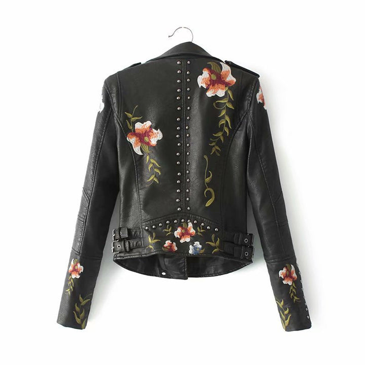 Chaqueta negra de cuero sintético para mujer con flores bordadas y tachuelas. Versátil estilo biker audaz.