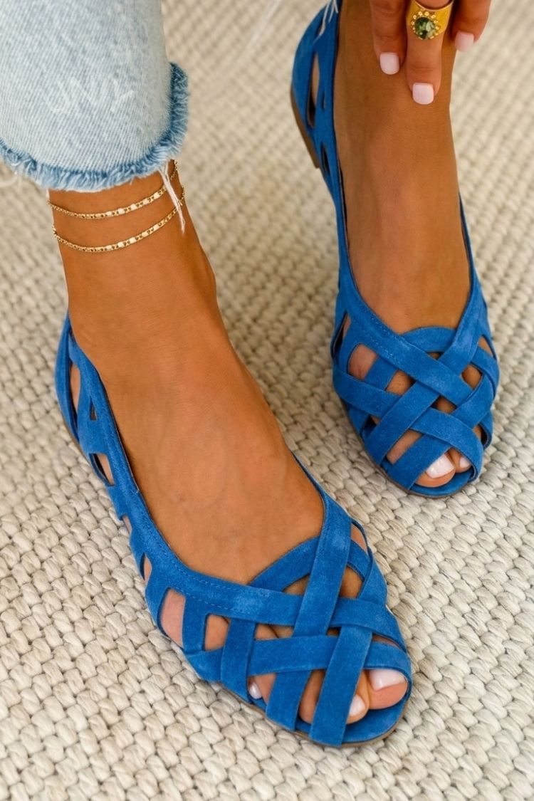 Primer plano de las tiras trenzadas en sandalias planas de mujer, detalle de moda para verano.