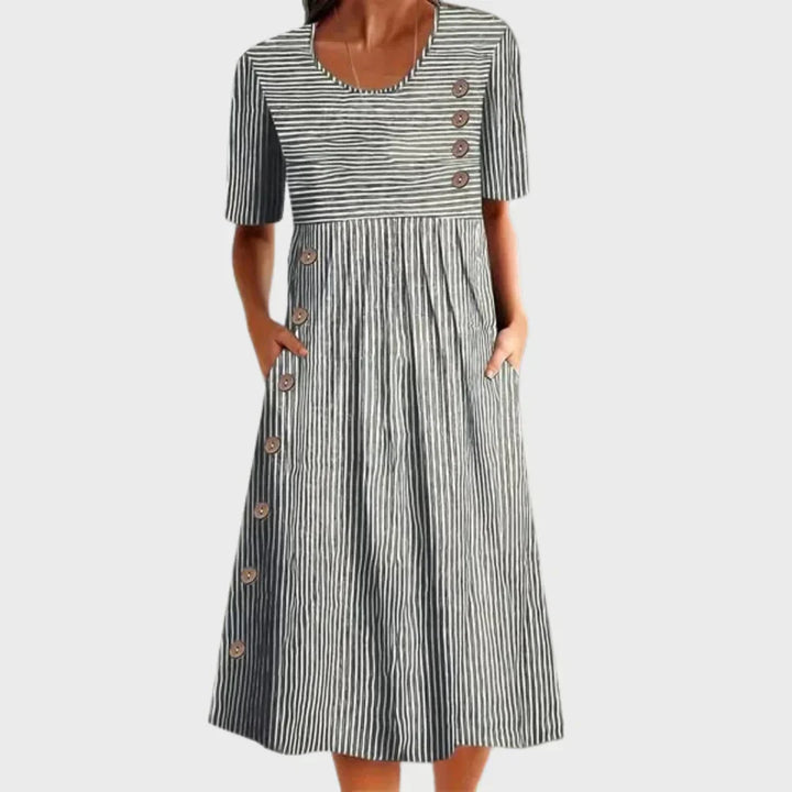 Mujer vistiendo vestido rayado de algodón transpirable, ligero y confortable. Ideal para días cálidos de verano.