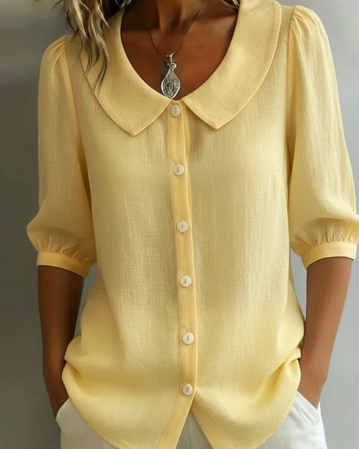 Modelo vistiendo blusa elegante cuello Peter Pan, manga fluida. Un look versátil para mujer, primavera/verano.