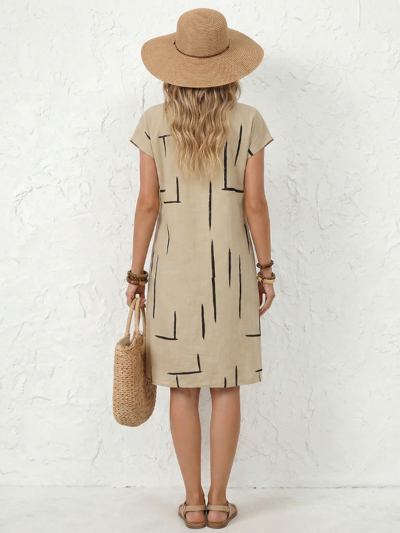 Mujer luciendo vestido midi de algodón lino con escote V y estampado geométrico. Estilo casual de verano.