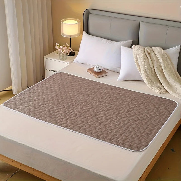 Protector de cama lavable y reutilizable para incontinencia, ofrece protección absorbente e impermeable para colchón.