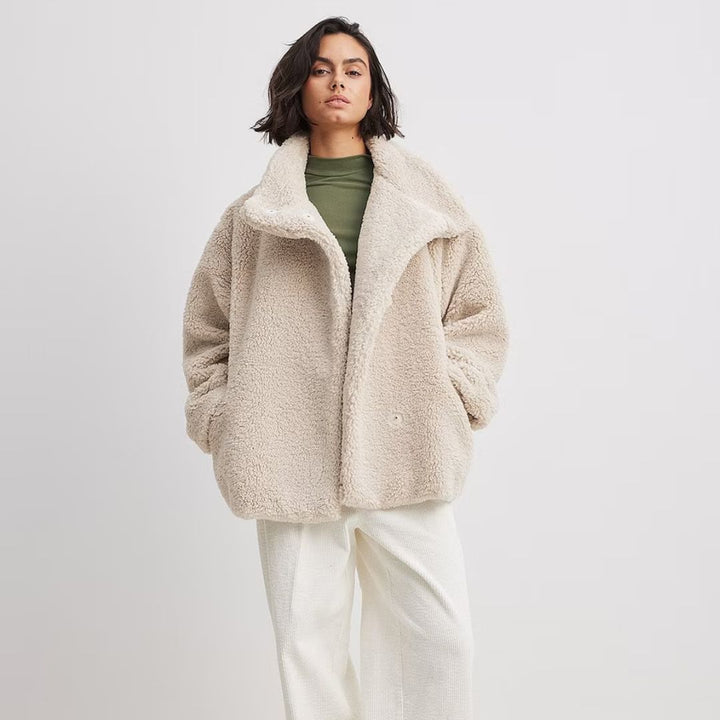 Mujer vistiendo abrigo oversize beige de invierno, con estilo elegante y casual. Perfecta chaqueta cálida de moda.
