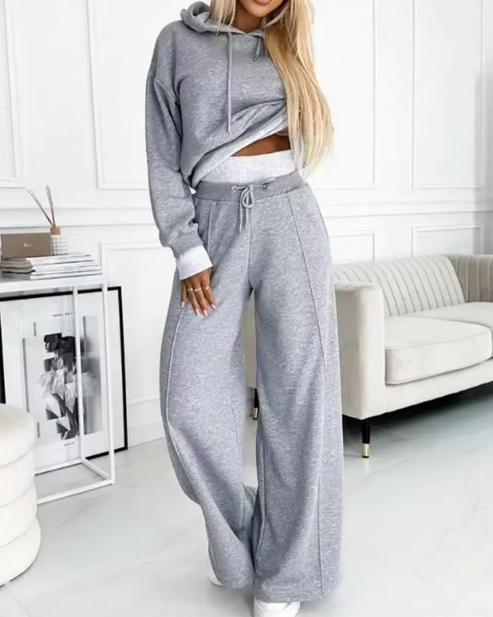 Mujer vistiendo conjunto de sudadera oversize y pantalón ancho, outfit deportivo casual y moda urbana.