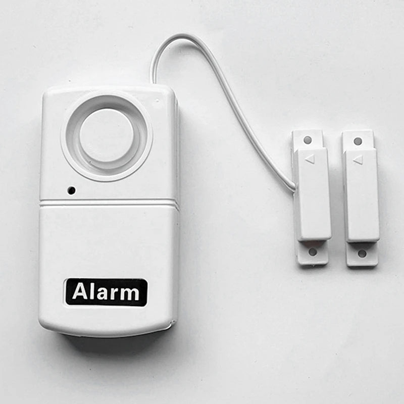 Sensor de alarma de seguridad portátil instalado en puerta. Protege tu hogar con fácil instalación y alerta inmediata.