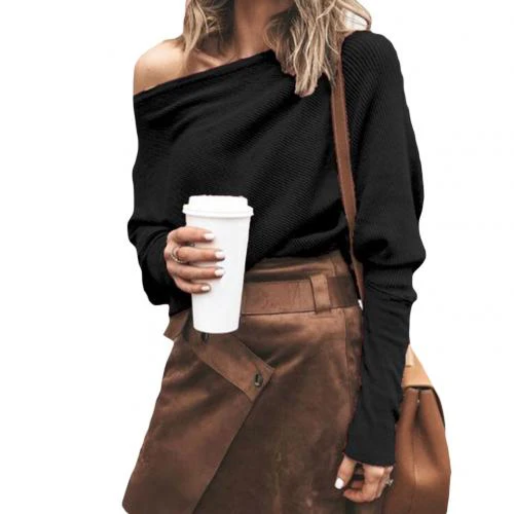Mujer vistiendo suéter Rosa Viento con hombros descubiertos, look moderno y casual de otoño.