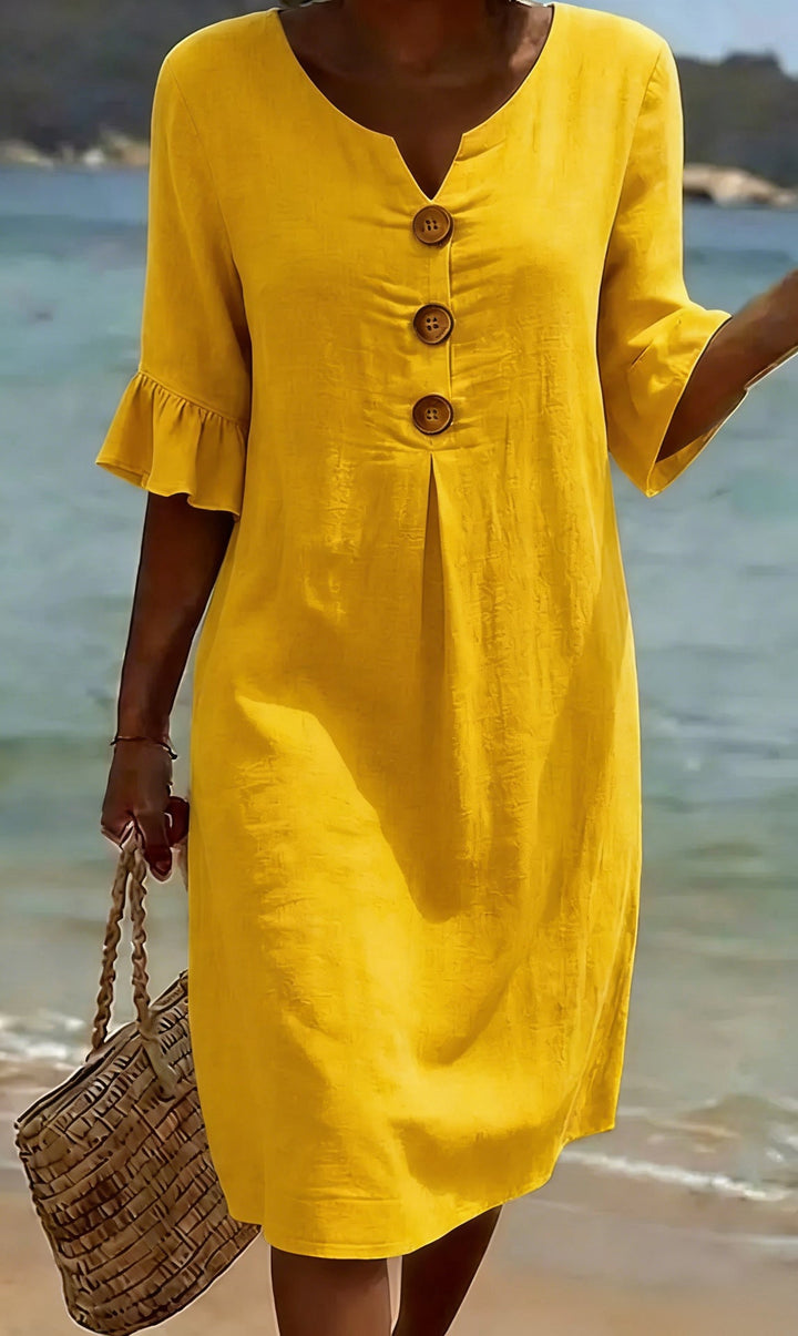 Modelo vistiendo vestido holgado de algodón y lino, mangas abullonadas. Perfecto para un día de playa o verano.