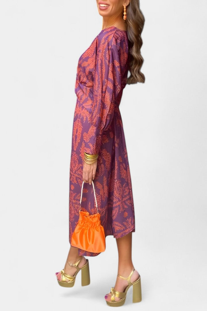 Vestido Elara maxi de colores vibrantes, escote V y nudo estilizador. Estilo moderno para primavera y celebraciones.
