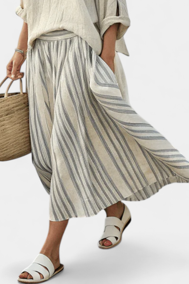 Elegante conjunto Aurora de blusa cómoda y falda midi a rayas. Moda femenina beige para primavera-verano, estilo casual.