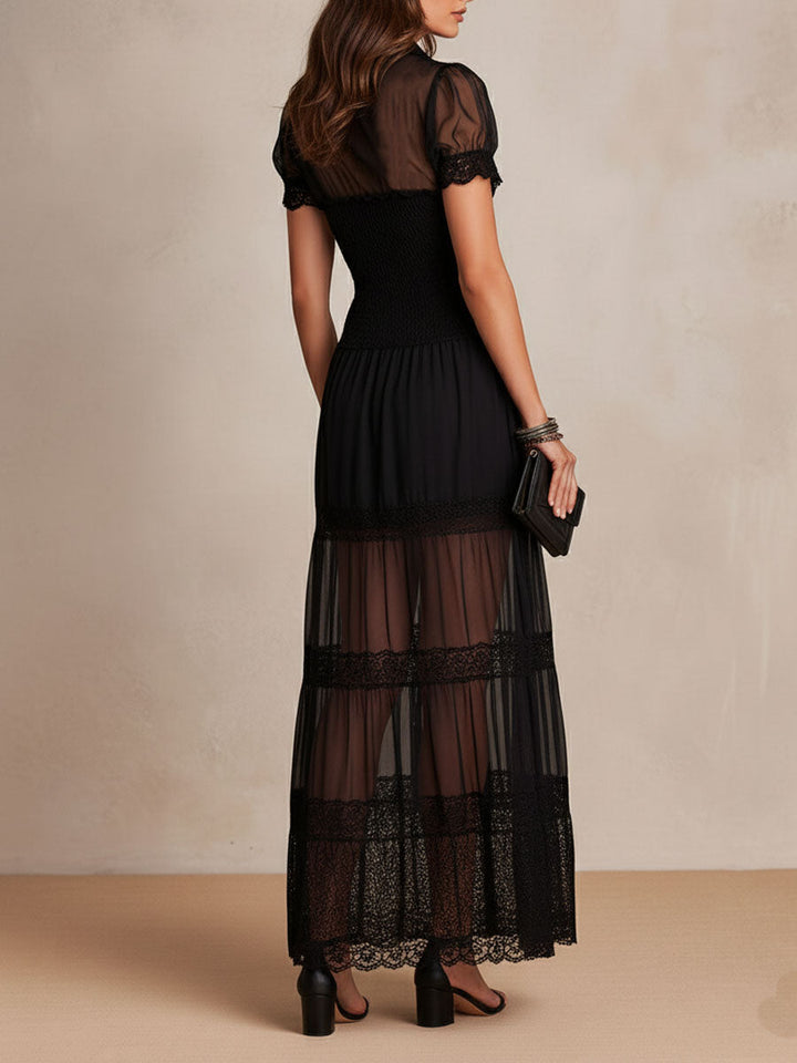 Vestido maxi negro sensual con transparencias en el escote y encaje decorativo, perfecto para una noche elegante.