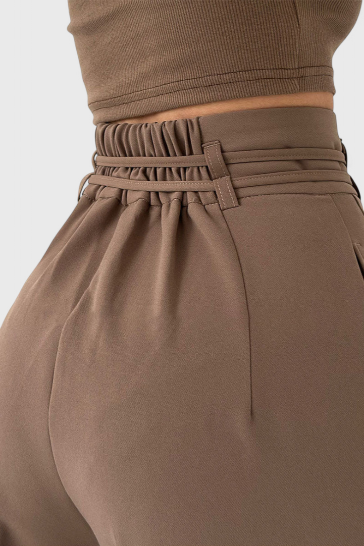 Mujer luciendo pantalones fluidos de cintura alta con cordones, ideales para un look versátil y cómodo.