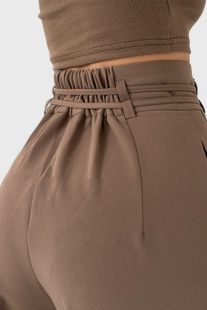 Mujer luciendo pantalones fluidos de cintura alta con cordones, ideales para un look versátil y cómodo.