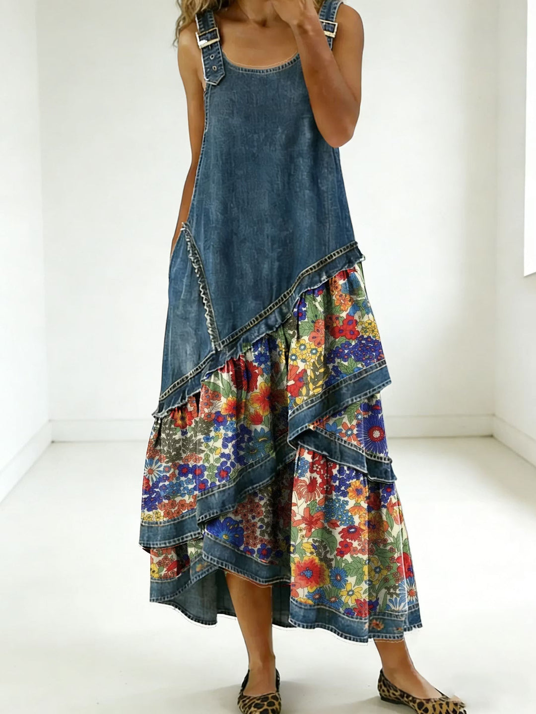 Detalle de vestido maxi bohemio de mujer, mostrando patchwork denim, estampado floral y tejido fluido para comodidad.
