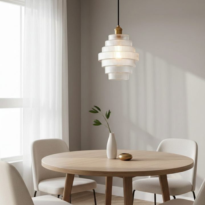 Detalle de lámpara colgante con pantalla de cristal y base de latón antiguo. Iluminación de diseño para cocina.