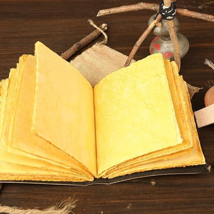 Detalle del grabado de gato místico en el cuaderno de cuero vintage, ideal para escritura artesanal.