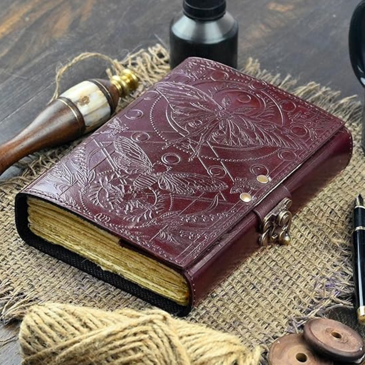 Cuaderno artesanal de cuero marrón con elegante cerradura, para diario personal o registro de notas.