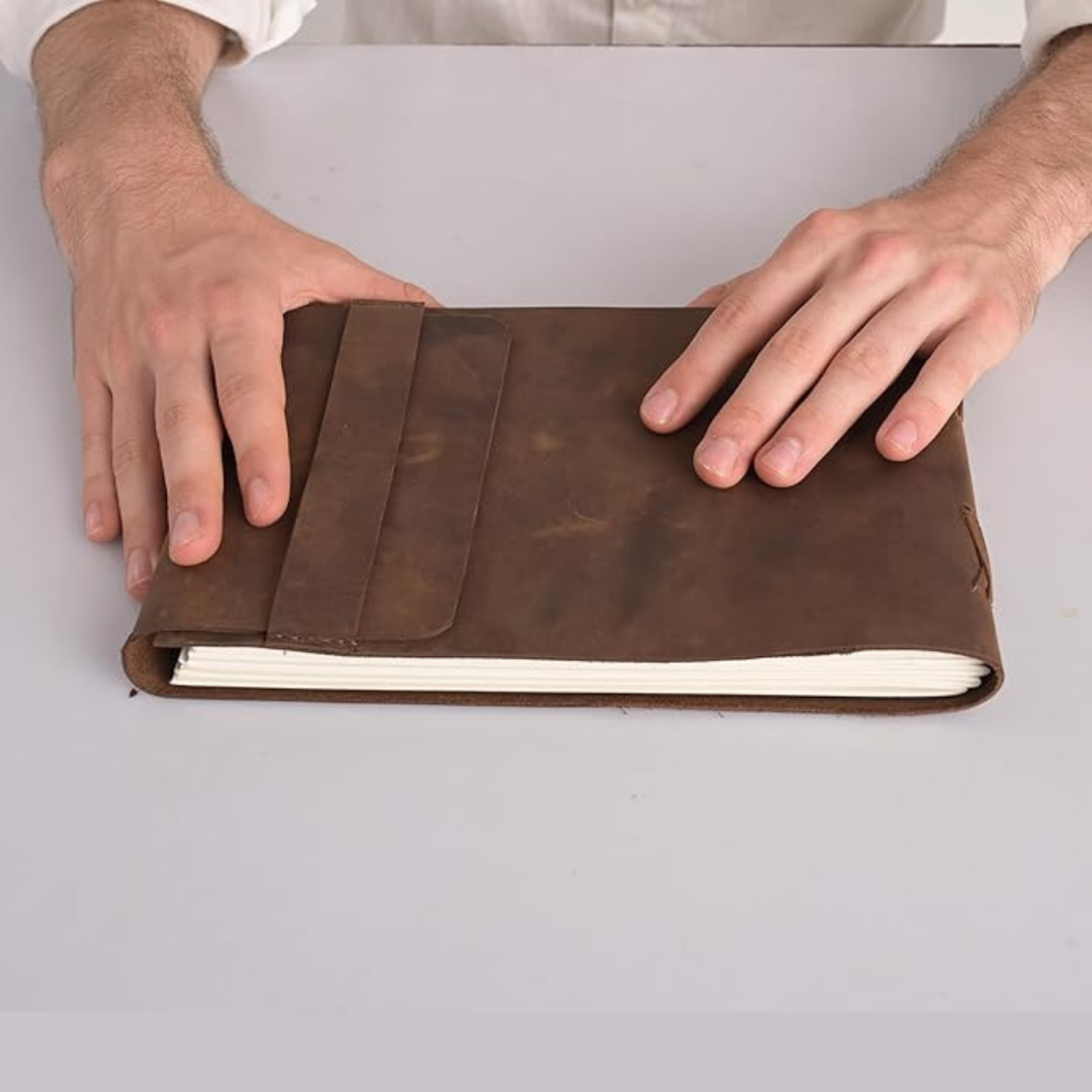 Vista superior de un cuaderno de cuero para escritura y dibujo, evocando un estilo vintage y libreta antigua.