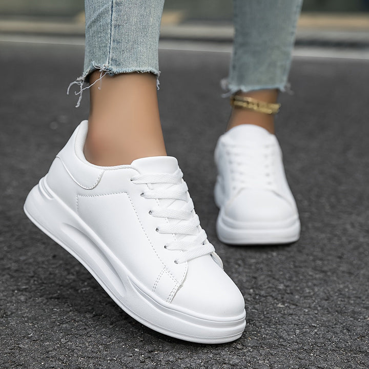 Modelo de zapatillas HERTA, calzado blanco con plataforma. Look moderno y fresco, ideal para moda femenina casual.