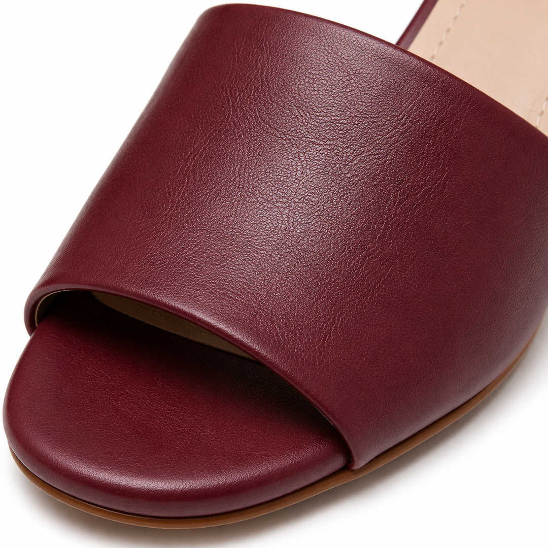 Mujer luciendo sandalias burdeos elegantes. Calzado cómodo y versátil, ideal para la moda femenina veraniega.
