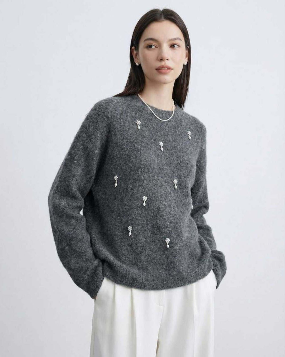 Detalle de tejido: suéter gris de cuello redondo. Suave jersey para moda femenina de otoño.