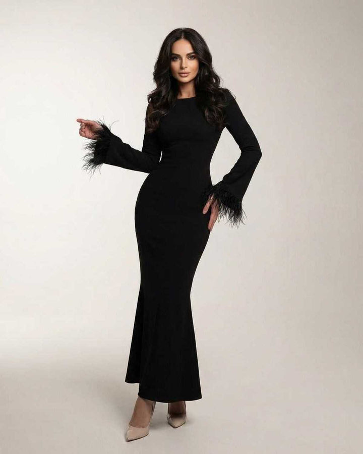 Vestido maxi sirena negro elegante para mujer con puños de plumas. Ideal para noche, fiesta o evento formal.