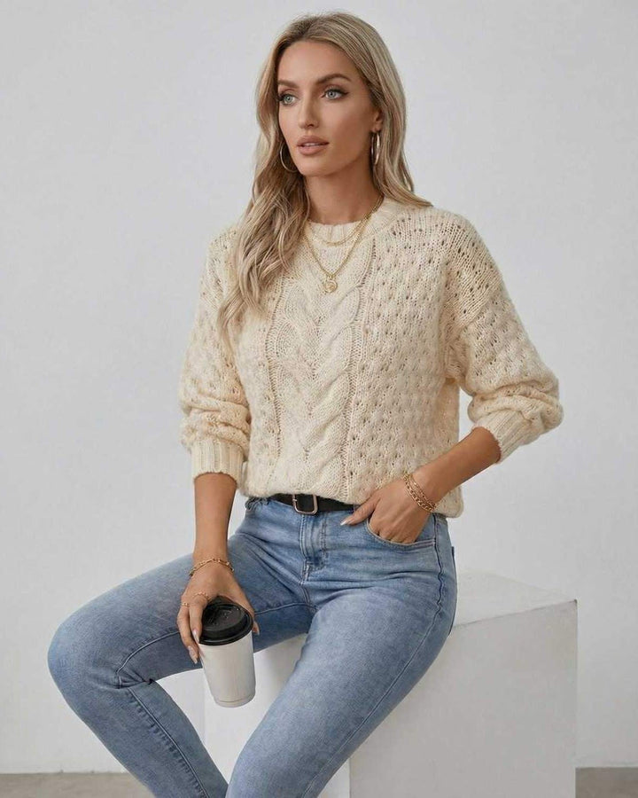 Suéter de mujer en color crema con patrón trenzado distintivo, cuello redondo. Moda otoño-invierno.