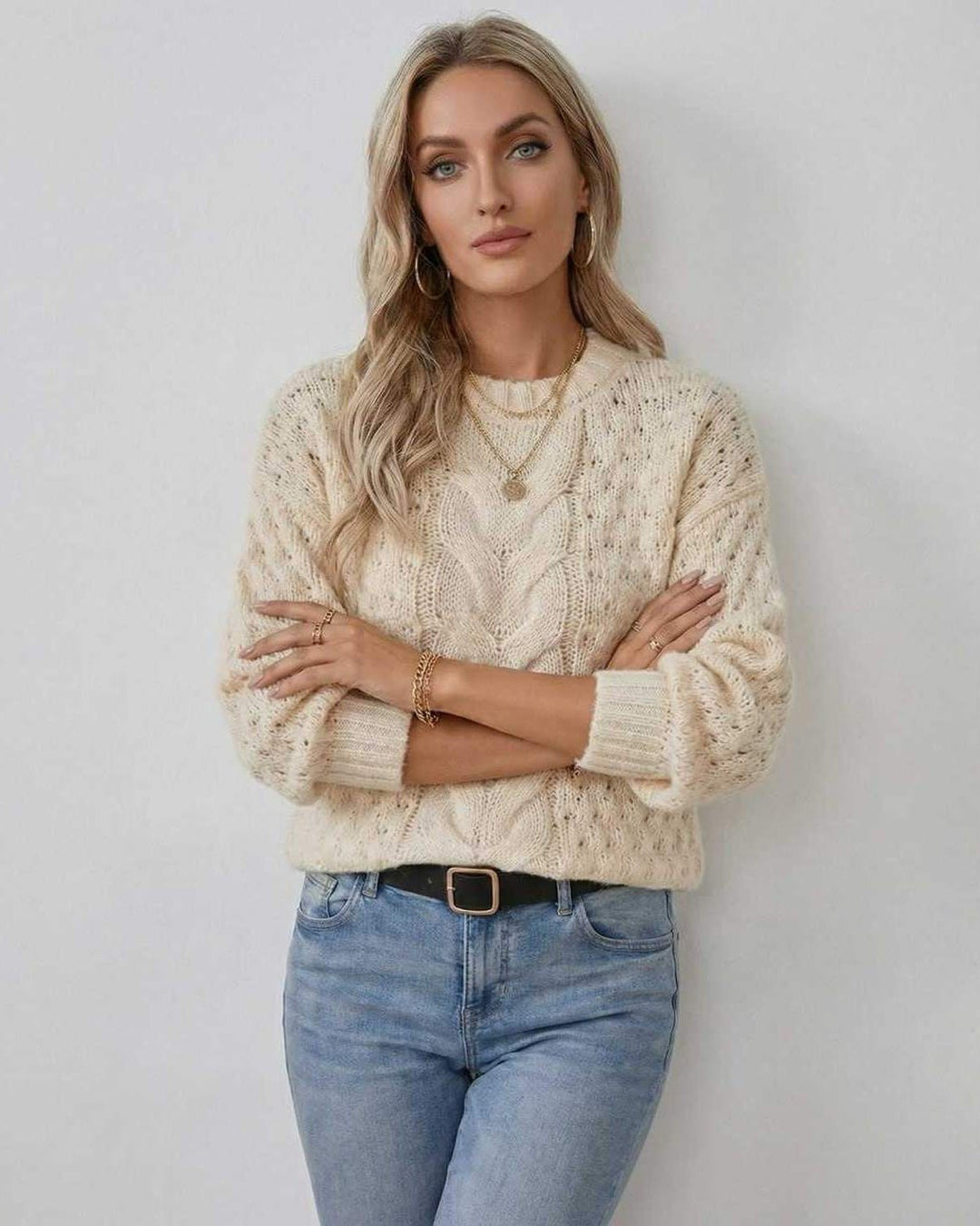 Suéter crema de punto trenzado para mujer, con cuello redondo y manga larga.