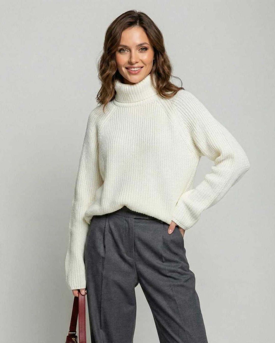 Modelo luciendo suéter blanco de cuello alto, ajuste relajado. Moda de invierno y otoño para mujer.