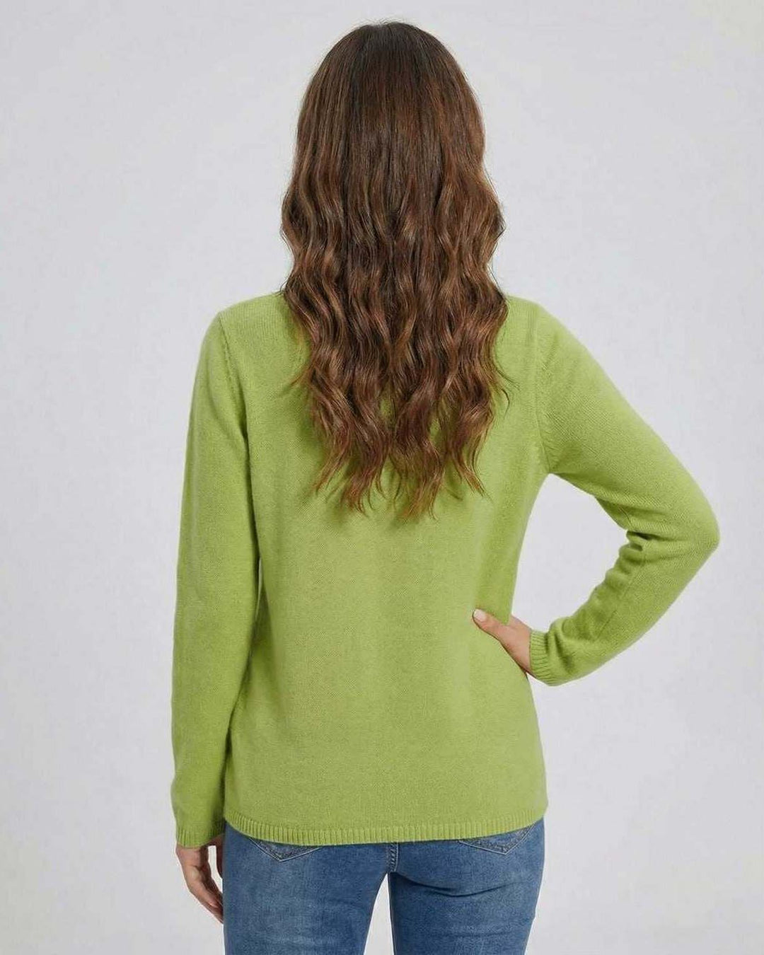 Suéter verde elegante para mujer, estilo moderno con cuello en V y detalle asimétrico de botón. Manga larga.