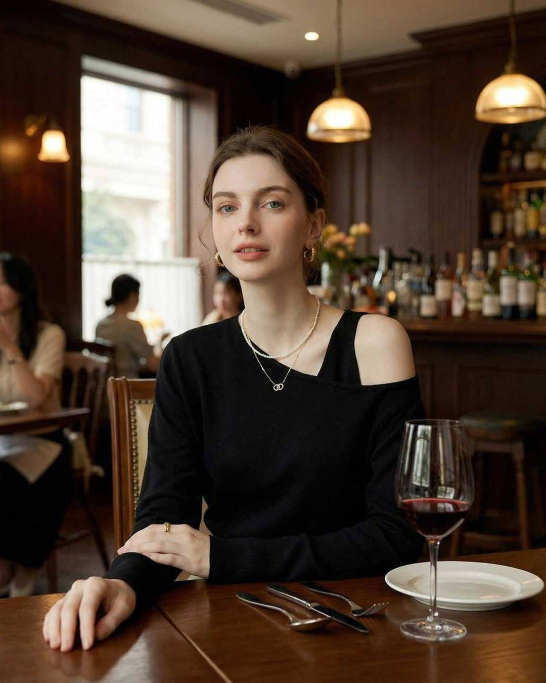 Jersey negro off shoulder para mujer. Suéter asimétrico elegante, ideal para un look casual chic de otoño invierno.