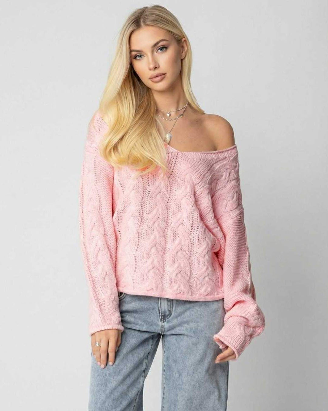 Primer plano de la textura suave del suéter rosa de cuello V, manga larga, confort y estilo para mujer en invierno.
