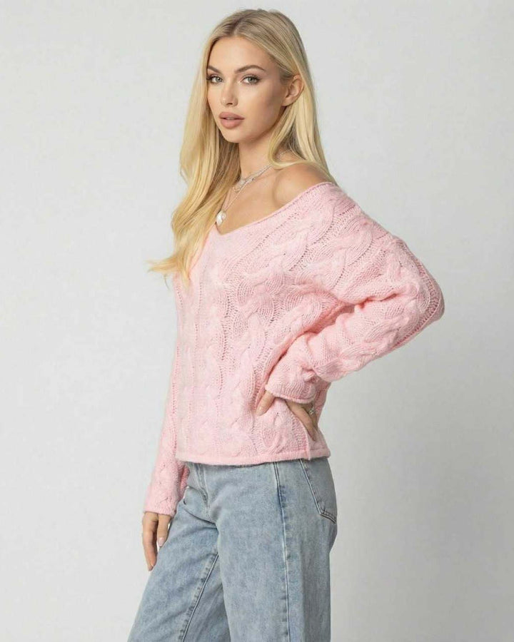 Mujer vistiendo suéter rosa de cuello V, estilo casual moderno, ajuste relajado, perfecto para el día a día.