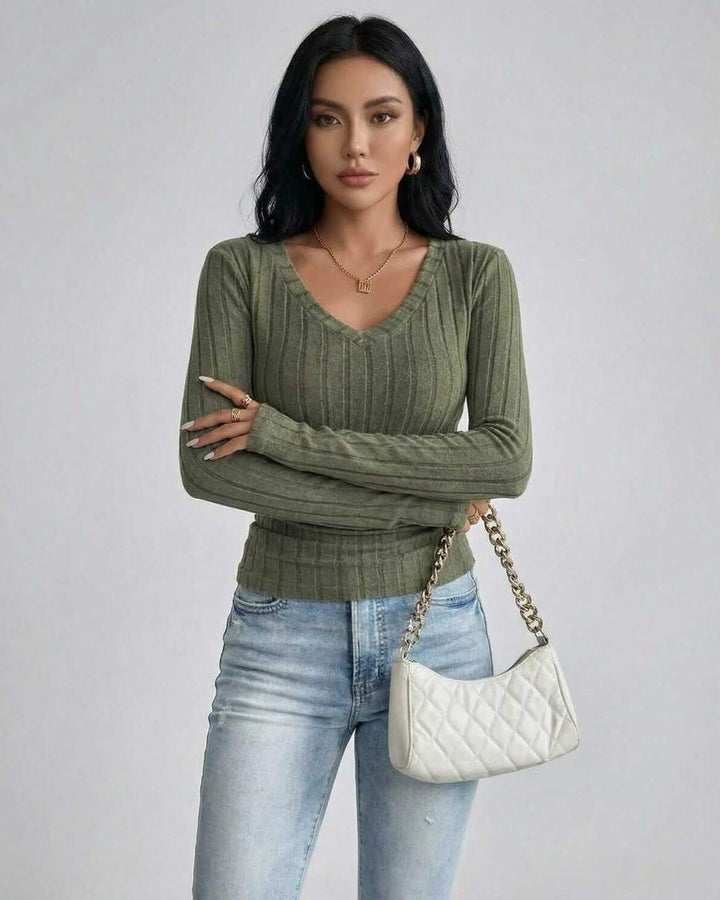 Mujer luciendo suéter verde ajustado con escote en V y manga larga. Estilo casual chic para otoño-invierno.