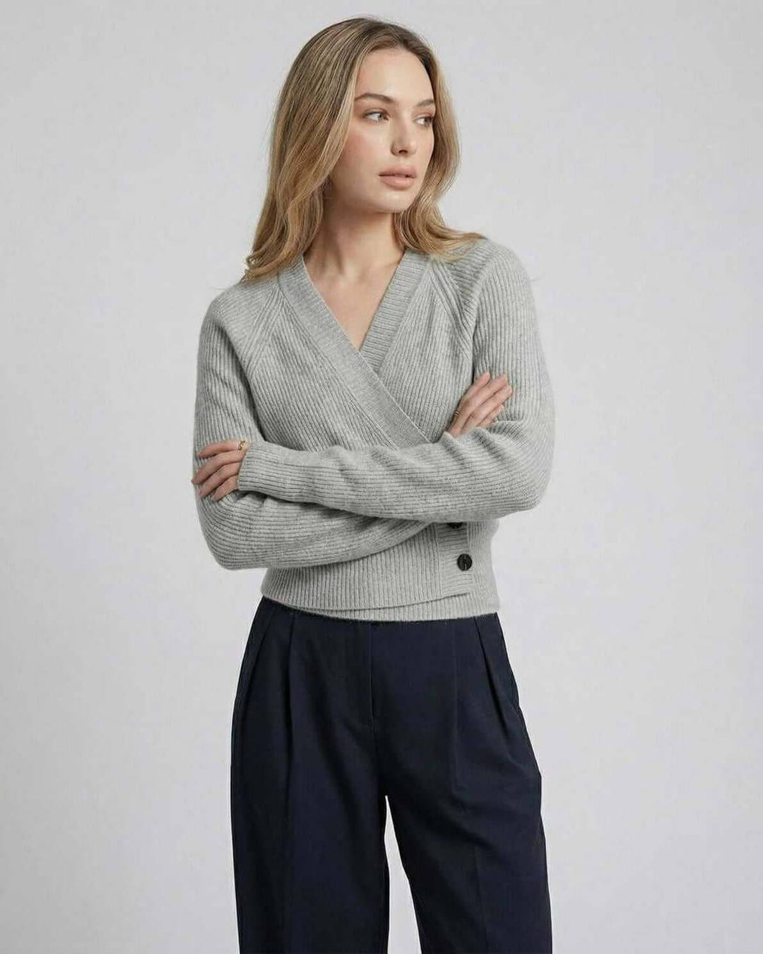 Detalle de suéter cruzado blanco para mujer. Tejido suave, silueta delgada, look elegante de otoño/invierno.
