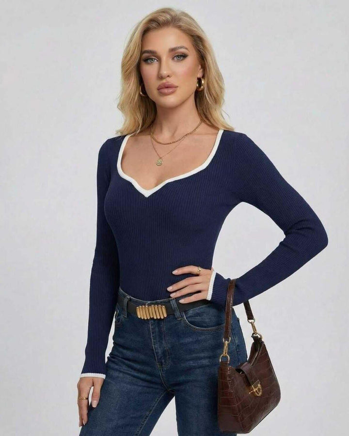 Modelo femenina con suéter blanco de cuello V ajustado. Estilo sofisticado y casual para el invierno.