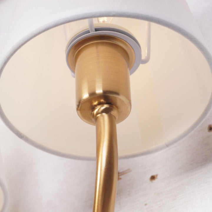 Luz cálida y decorativa con aplique de pared doble dorado, estilo hotelero de lujo.
