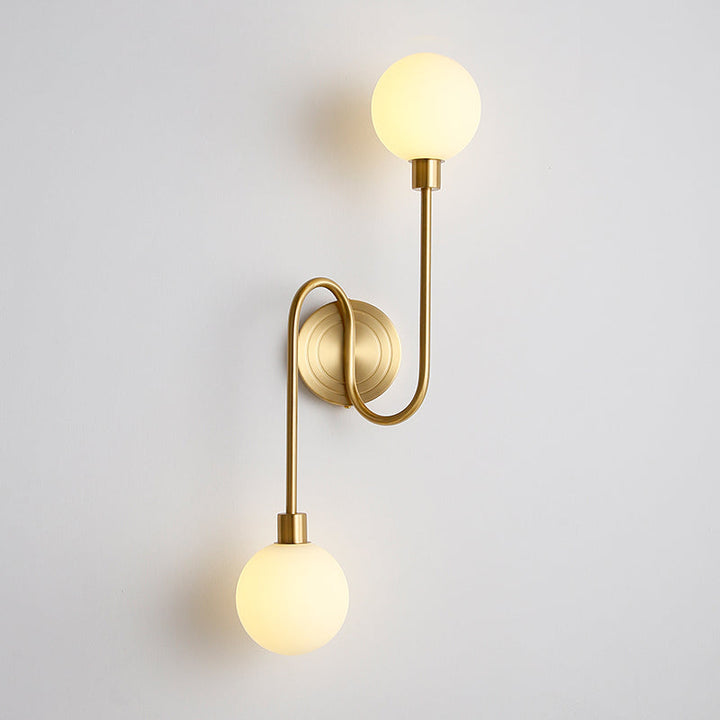 Aplique de pared latón con dos globos cristal blanco. Iluminación moderna y elegante para hogar.