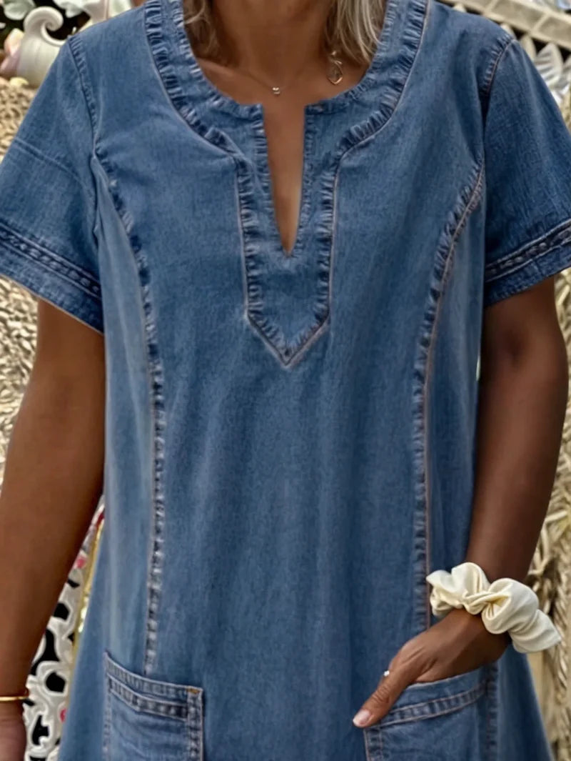 Detalle del escote V y tela suave del vestido de denim para mujer, diseño moderno y femenino.