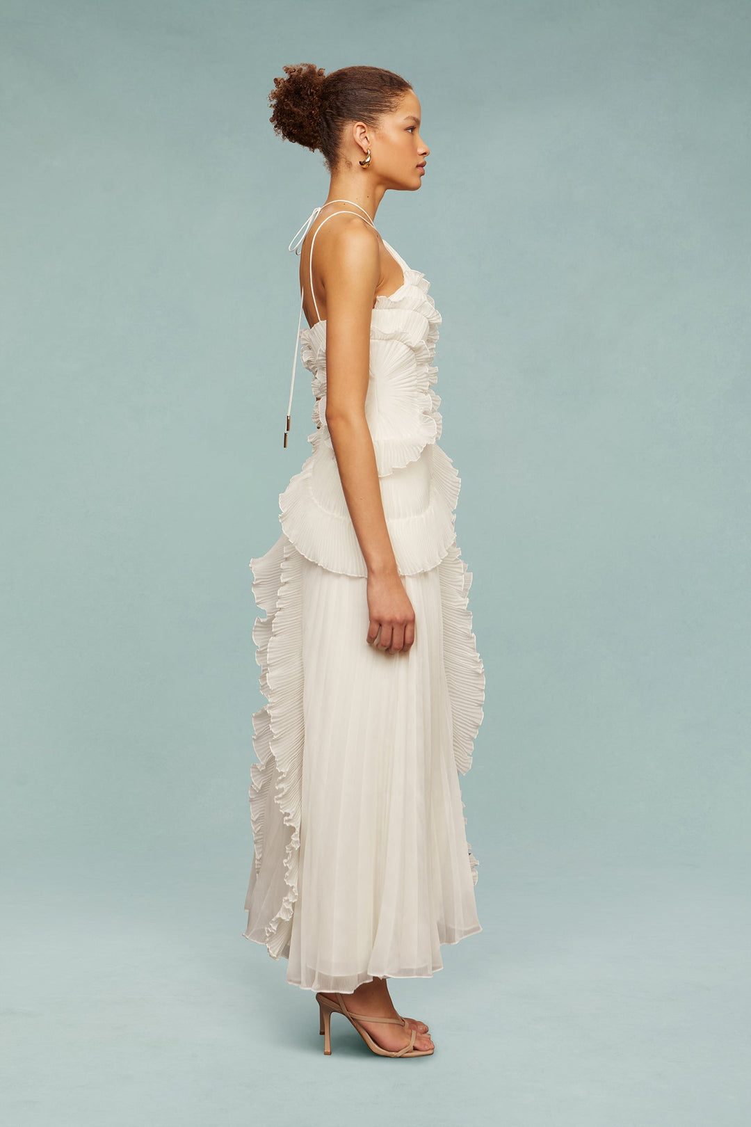 Vestido blanco con escote halter. Volantes sutiles, ideal para ceremonias y eventos primaverales.