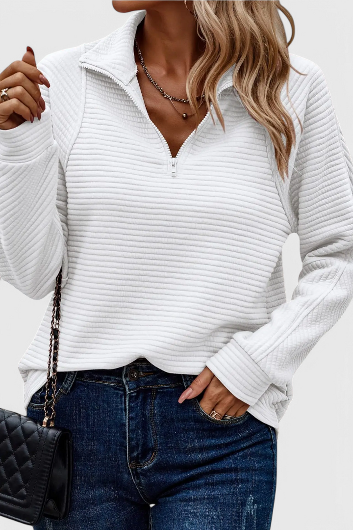 Jersey de mujer con escote en V y cremallera. Prenda esencial en moda femenina, cómoda y versátil.