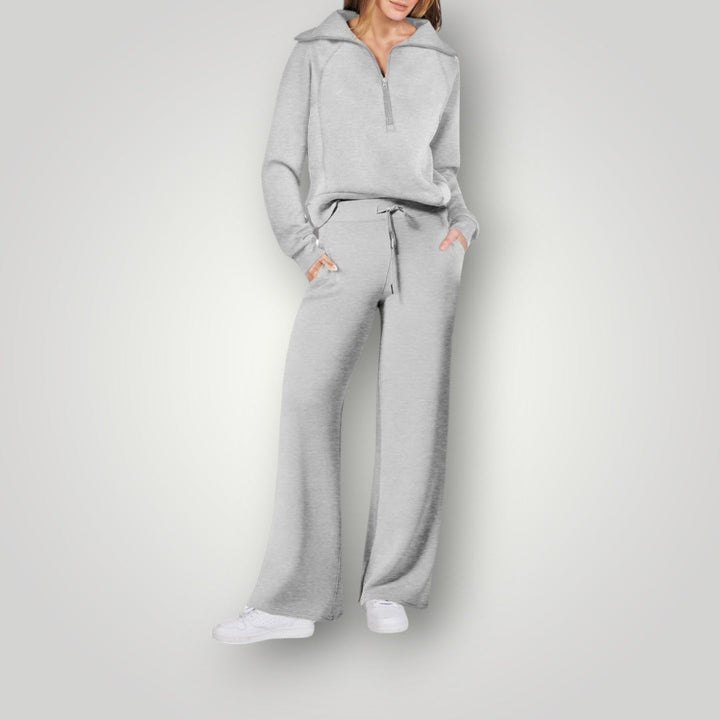 Modelo posando con conjunto loungewear de suéter de manga larga y pantalón jogger, cómodo y moderno.
