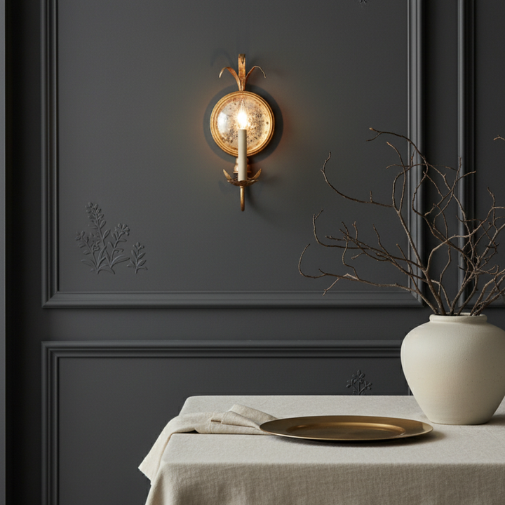 Iluminación vintage: aplique de pared de latón antiguo con espejo. Luces vela crean ambiente acogedor.