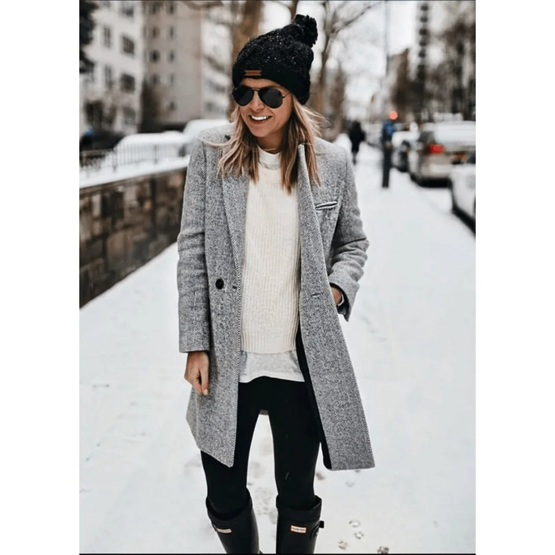 Mujer elegante luciendo un abrigo trench coat de espiga, moda invierno atemporal y chic.