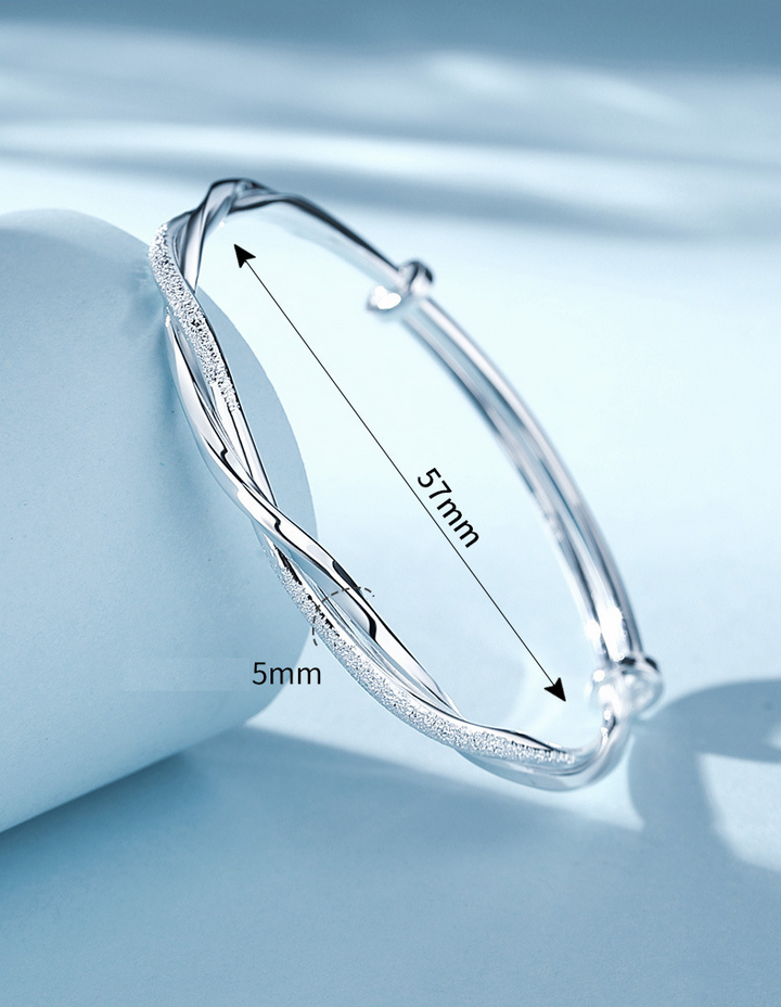 Pulsera Elara de plata trenzada con brillo pulido intenso, accesorio minimalista que irradia luz.