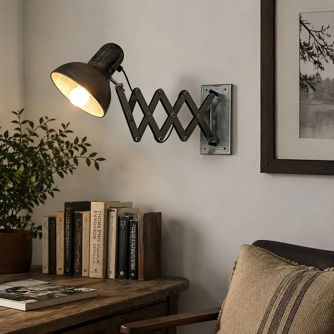 Aplique industrial de metal envejecido con brazo de tijera, perfecto para iluminación vintage interior.