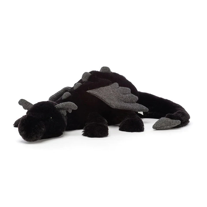 Niño feliz abrazando un peluche de dragón suave y tierno, su nuevo juguete de fantasía.