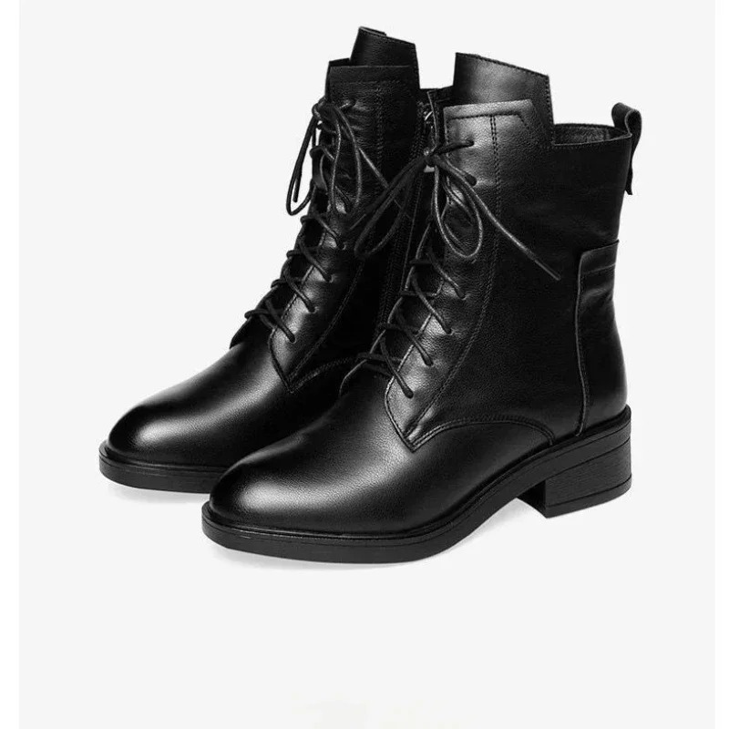 Moda de botines negros de mujer, con punta afilada y diseño elegante, perfecto para un look de invierno.